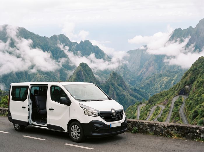 Renault Trafic blanc, porte latérale ouverte, sur un belvédère face au cirque de Cilaos